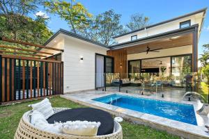 a backyard with a swimming pool and a house at Retreat at Byron in Byron Bay