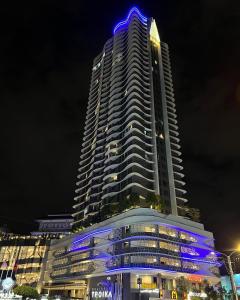 a tall building with blue lights on it at night at Rizz Residence Troika KB in Kota Bharu