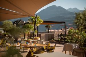 Eine Terrasse mit Tischen und Stühlen vor dem Hintergrund der Berge in der Unterkunft Muchele Boutique Hotel in Burgstall