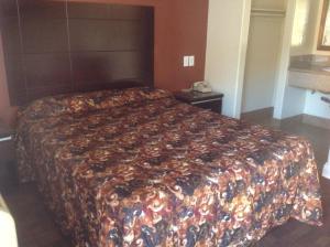 a bed in a hotel room with a blanket on it at Bronco Motel South Central in Los Angeles +6 photos