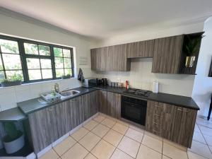 a kitchen with wooden cabinets and a sink at Getaway cottage in Lovemore Park