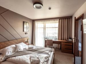 sypialnia z łóżkiem, biurkiem i oknem w obiekcie Villa Cam In Ski w mieście Duszniki Zdrój