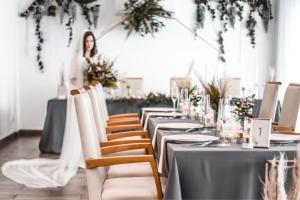 a woman standing in front of a long table with chairs at Dubno Eat & Sleep in Nová Dubnica