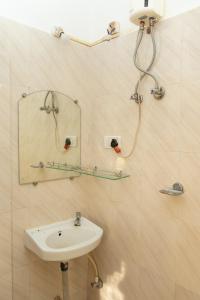 uma casa de banho com um lavatório e um espelho em Morjim Guest House em Morjim