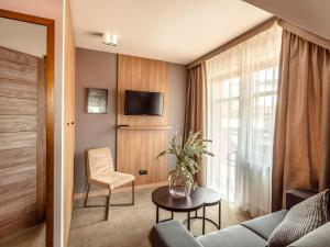 a living room with a couch and a table at Villa Cam In Ski in Duszniki Zdrój