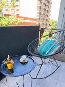 una mesa y una silla en un balcón con una taza de café en 2 ambientes cerca de la playa, en el centro en Mar del Plata