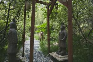two statues of people standing in a garden at Raven Yurt - Yurtopia in Aberystwyth