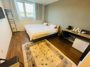 a bedroom with a bed and a desk and a rug at Megu fuji 2021 - Vacation STAY 74532v in Fujiyoshida