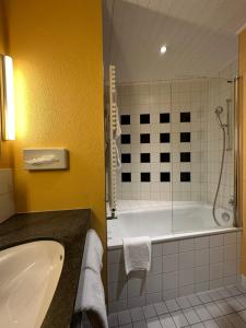 a bathroom with a tub and a sink and a shower at Residence am Marktplatz in Interlaken