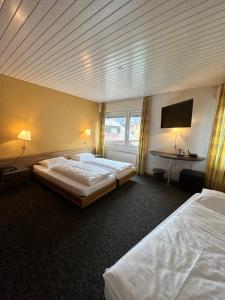 a hotel room with two beds and a flat screen tv at Residence am Marktplatz in Interlaken