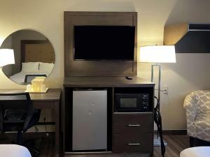 een hotelkamer met een televisie en een spiegel bij Econo Lodge Spring Lake near Fort Bragg in Spring Lake