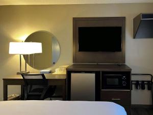 een hotelkamer met een televisie en een bureau met een bed bij Econo Lodge Spring Lake near Fort Bragg in Spring Lake