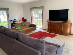 ein Wohnzimmer mit Couch und Flachbildfernseher in der Unterkunft CRALS - Casa da Guilheta in Esposende