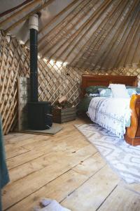 a bedroom with a bed and a woodburning stove at Raven Yurt - Yurtopia in Aberystwyth