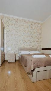 a bedroom with a bed and a wall at Rosheli Apartments in Manglisi