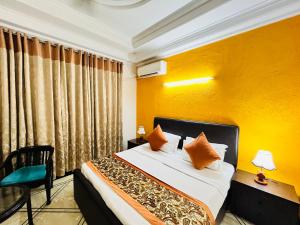 a bedroom with a bed and a yellow wall at Hotel Dayal Regency, Shushant Lok sector 29, Near Fortis Hospital in Gurgaon
