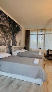 a bedroom with two beds and a large window at Rosheli Apartments in Manglisi