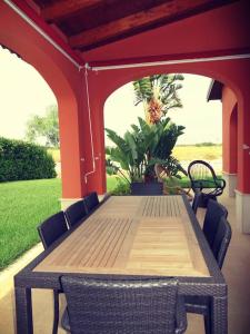 un tavolo e sedie in legno su un patio di Villa -Resort Marinagri a Policoro