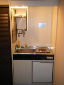 a small kitchen with a sink and a stove at Sunplaza Rinkai in Osaka