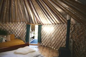 een slaapkamer met een bed in een tent bij Raven Yurt - Yurtopia in Aberystwyth