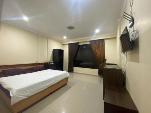 1 dormitorio con 1 cama y TV de pantalla plana en MAHANAIM HOTEL, 