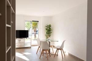a dining room with a table and chairs and a tv at Loft vistes al mar 50 mts to Palamós Beach in Palamós