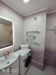 a bathroom with a washing machine and a shower at Апартаменты со всеми удобствами. in Oral