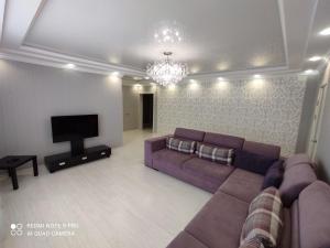 a living room with a couch and a tv at Апартаменты со всеми удобствами. in Oral