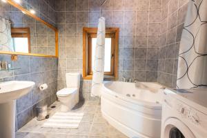 un bagno con vasca, WC e lavandino di Sakin Vadi Villas a Marmaris Altre 25 foto