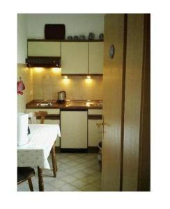 a kitchen with white cabinets and a table in it at Sport-Alpin-Wohnung-1 in Oberstdorf