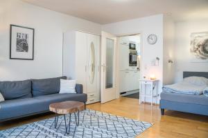 een woonkamer met een blauwe bank en een tafel bij Apartment und WG-Doppelzimmer Sonnenhalde in Tübingen