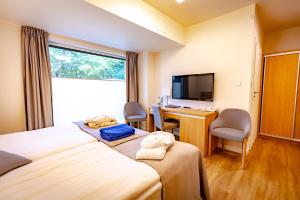 a hotel room with two beds and a desk and a television at Eva Park Life & Spa in Konstancin-Jeziorna