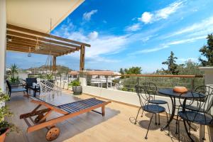 a patio with a table and chairs on a balcony at Colonial View Apartment in Faliraki