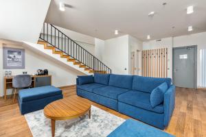 a living room with a blue couch and a staircase at Gudauri Lodge in Gudauri