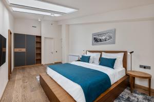 a bedroom with a large bed with blue pillows at Gudauri Lodge in Gudauri