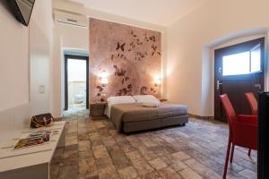 1 dormitorio con 1 cama y una pared con una pintura en Karama en Dorgali