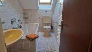 a bathroom with a sink and a tub and a toilet at Cheerful Roof Flat in a Private German Style House in Mannheim