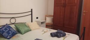 een slaapkamer met een bed met groene en blauwe kussens bij Casa Fiori di Arancio in Valledoria