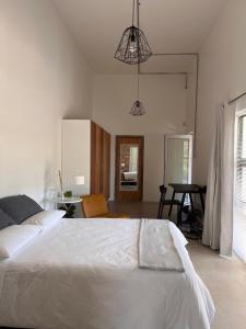 een slaapkamer met een wit bed en een tafel bij GreenHouse APARTMENT in Mount Road