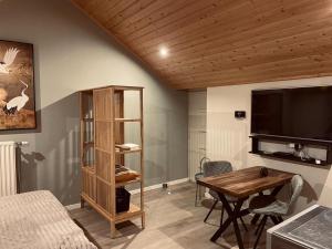 a living room with a table and a tv at Vakantiehuis de Heide in Bergen op Zoom