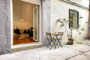 a patio with a table and chairs in front of a building at Charming Casa de Campo Madrid in Madrid