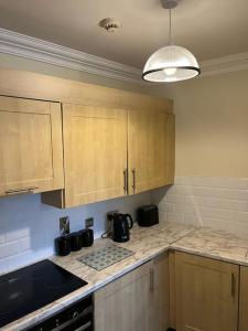 uma cozinha com armários de madeira e uma bancada em Foyle View Apartment em Derry