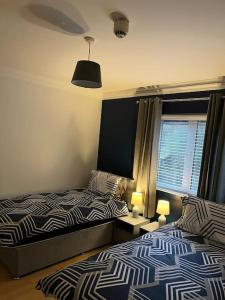 um quarto com 2 camas, uma janela e 2 candeeiros em Foyle View Apartment em Derry