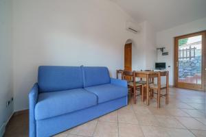 a blue couch in a living room with a table at La Paolina Vista Mare e Natura in Marciana Marina
