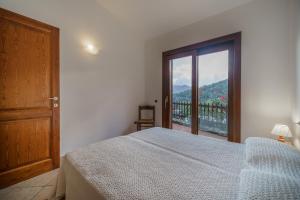 a bedroom with a bed and a large window at La Paolina Vista Mare e Natura in Marciana Marina