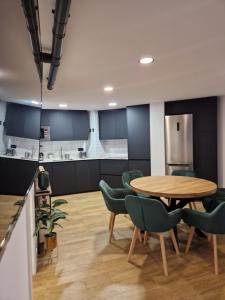 a dining room with a table and green chairs at Brand New Apartment very cosy and awesome display close to the ski slope! private parking in Sierra Nevada