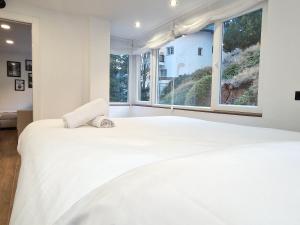 a bedroom with a large white bed with a large window at Brand New Appartment very cosy and awesome display close to the ski slope! private parking in Sierra Nevada