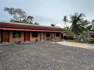 a brick building with a parking lot in front of it at Ujud Sepakat Homestay in Melaka
