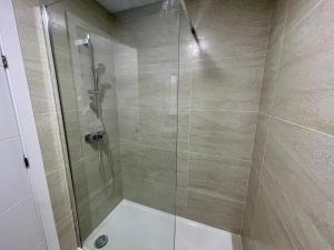 a bathroom with a shower with a glass door at LHOME CÁDIZ in Cádiz +37 photos
