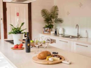 a kitchen counter with wine glasses and a plate of food at Driftwood Beach House in Kiama